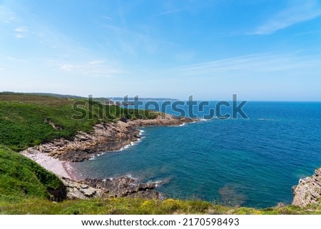 View of the coastline lined with pink sandstone cliffs and the deep blue waters of the Channel in Brittany Royalty-Free Stock Photo #2170598493
