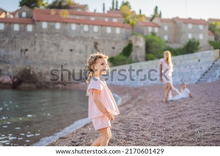 Mother and two children daughter and son tourists on background of beautiful view St. Stephen island, Sveti Stefan on the Budva Riviera, Budva, Montenegro. Travel to Montenegro concept