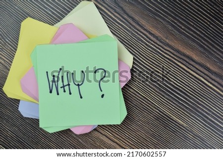 Concept of Why? write on sticky notes isolated on Wooden Table.