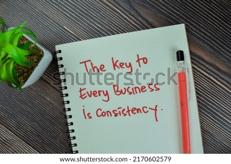 Concept of The Key to Every Business is Consistency write on a book isolated on Wooden Table.