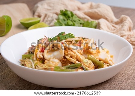 Sukiyaki dried squid Thai food in white bowl on wooden background