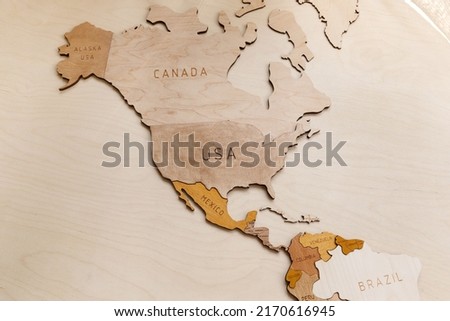 Wooden map of the world on a light background. Self made. Plywood. In beige tones. North and Latin America. Geography. USA, Canada, Alaska, Mexico, Brazil, Cuba, Venezuela. Royalty-Free Stock Photo #2170616945