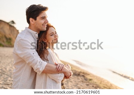 Close up profile happy satisfied smiling young couple two friends family man woman 20s in white clothes hug rest together at sunrise over sea beach ocean outdoor seaside in summer day sunset evening. Royalty-Free Stock Photo #2170619601