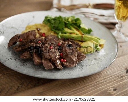 Meal of beef belly, avocado and mashed potatoes