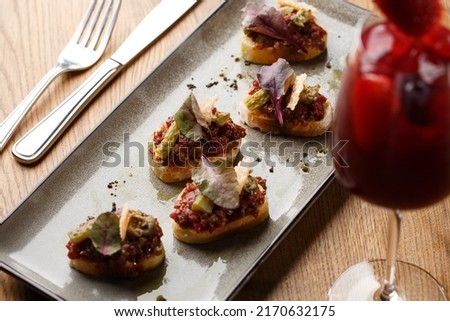 Four bruschettas with beef tartare on a plate, Crostini with Beef Tartare, beef Bruschetta, sandwich with raw gourmet beef