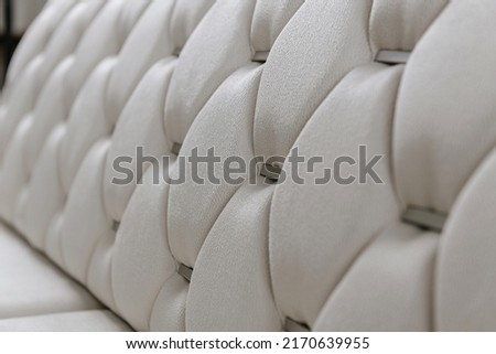 white sofa back with handmade patterns and metal inlays