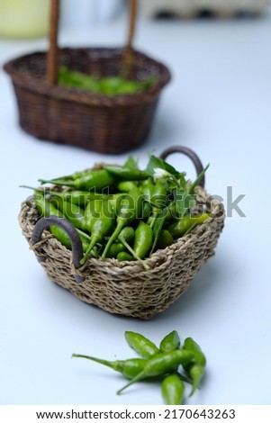 A high key picture of the most spicy chilli in the world called "cili padi kampung" or chilli padi on the table. The more spicy the food, the more people will love.