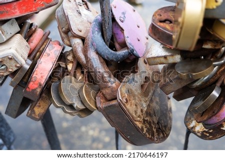 Metal padlocks on the fence of the bridge as a symbol of eternal love close-up. Selective focus