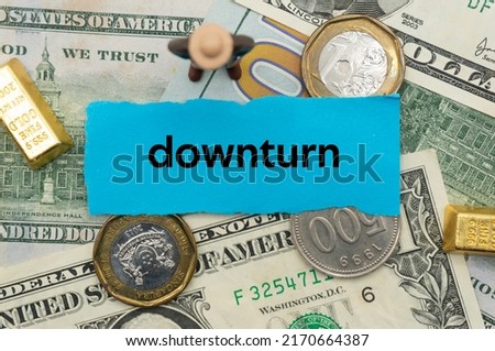 downturn.The word is written on a slip of paper,on colored background. professional terms of finance, business words, economic phrases. concept of economy.