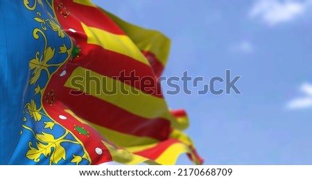 The Valencian Community flag waving in the wind on a clear day. The Valencian Community is an autonomous community of Spain. Seamless loop in slow motion