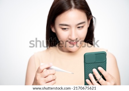 asian woman measure body temperature Connect with smart phone. Concept of female fertility and high luteinizing hormone. The right time to conceive a child. infertility Concept.