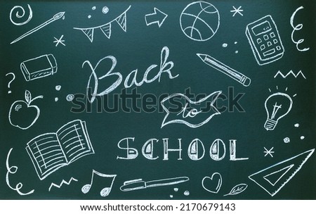Blackboard written with chalk with message and school supplies. Back to school concept