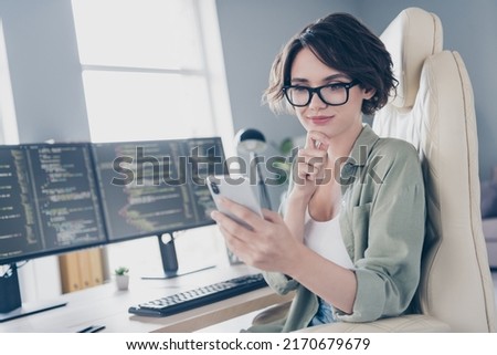 Photo of female system administrator have break contemplate online shopping holding cellphone indoors workplace