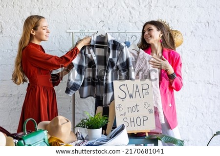 Young women at swap home party - clothes, shoes, bags, jewellery exchange between friends. Zero waste shopping, eco friendly concept, sustainable lifestyle. College life.  Royalty-Free Stock Photo #2170681041