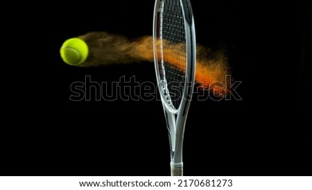 Freeze Motion Shot of Racket Hitting Tenis Ball Containing Orange Powder Royalty-Free Stock Photo #2170681273