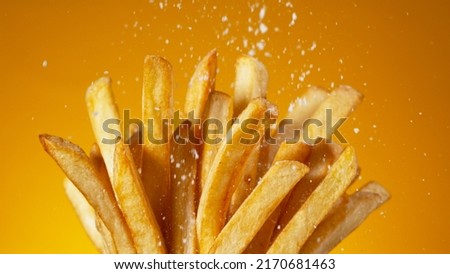 Detail Shot of adding Salt on French Fries, Close-up. Royalty-Free Stock Photo #2170681463