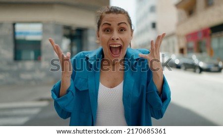 Young woman smiling confident surprised at street