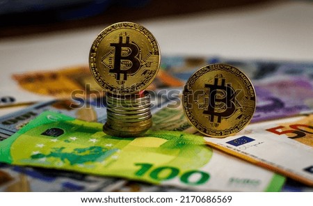 Bitcoins close-up on the background of paper bills of different countries.