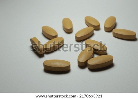 many pills and vitamins on a white background