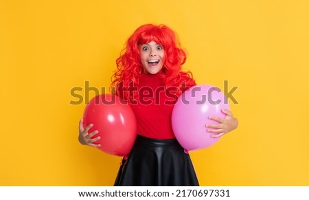 shocked teen child with party balloon on yellow background