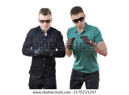 Two young hooligan men wearing sunglasses and leather gloves posing in fighting stance isolated on a white background Royalty-Free Stock Photo #2170721247
