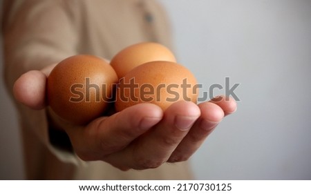 Fresh organic eggs on the hands of farmers.