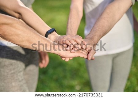 Close up picture of peples hands holding each other