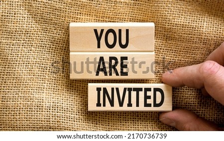 You are invited symbol. Concept words You are invited on wooden blocks. Businessman hand. Beautiful canvas table canvas background. Business and you are invited concept. Copy space.