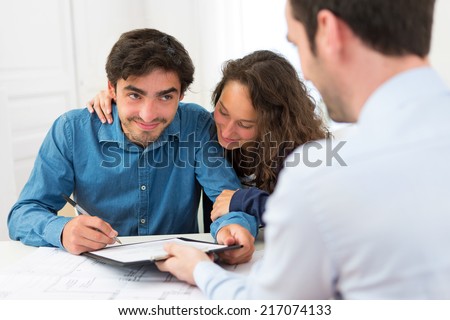 View of a Young attractive couple signing contract