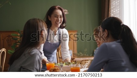Adult SME owner work at busy small cafe bar pub on cozy day carry plate tray for group asia people friend party at vegan shop. Enjoy talk order fresh menu eat meal drink fine dish diet salad bowl. Royalty-Free Stock Photo #2170750213