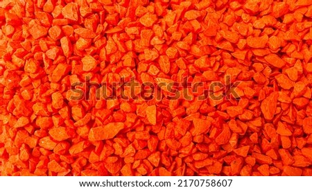 A pile of small reddish-orange stones for creating art