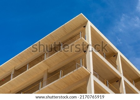 Looking up at the vertical supports, balconies and interior ceiling of a engineered timber multi story green, sustainable residential high rise apartment building construction project Royalty-Free Stock Photo #2170765919