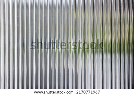 clear polycarbonate plastic background and texture. Transparent material Corrugated plastic surface use for partition wall, door or roofing. close up picture. Royalty-Free Stock Photo #2170771967