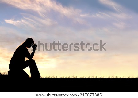 A silhouette of a young Christian woman is bowing her head in prayer, and desperation outside during sunset. Royalty-Free Stock Photo #217077385