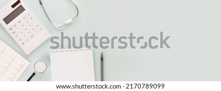 Medical insurance banner. Calculator, stethoscope, cardiogram and pen with notepad on a blue background with place for text. Banner of treatment and medical care. Banner size, flat lay Royalty-Free Stock Photo #2170789099