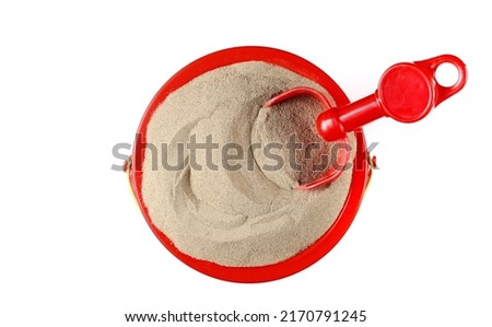 Plastic bucket, shovel and sand isolated on white, top view