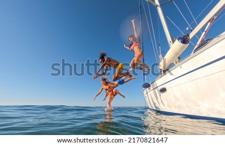 Multiracial friends jumping out of boat in the sea while having fun in their summer vacation  Royalty-Free Stock Photo #2170821647