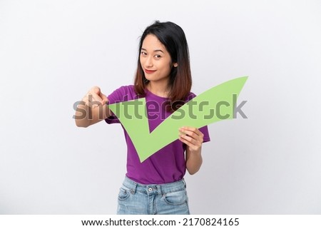 Young Vietnamese woman isolated on white background holding a check icon and pointing to the front