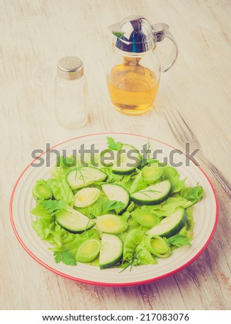 vintage photo of green salad made with lettuce, leek and cucumber