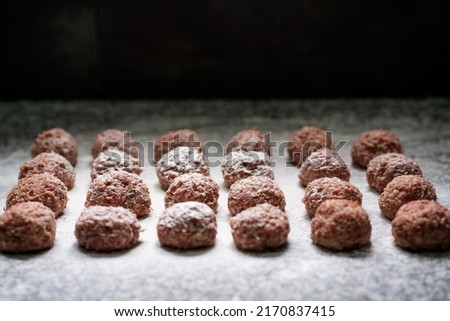 Raw meat balls, made with Argentinean minced meat, seasoned and on a marble table. Kitchen concept