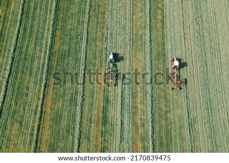 Tractors mowing a green grass for forage harves. Aerial view Royalty-Free Stock Photo #2170839475