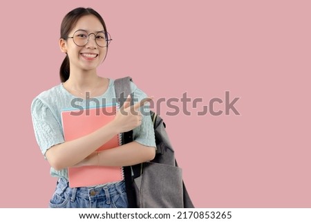 Young Asian student girl over isolated pink background pointing finger to the side