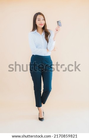 Portrait beautiful young business asian woman with phone and credit card on color isolated background