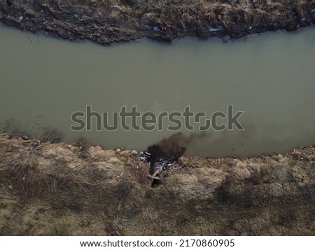 Polluted river. Hazardous chemicals are released into the river. Industrial waste water, aerial done view. Sewage drains into the river. Environmental pollution. Ecological catastrophe. Contamination. Royalty-Free Stock Photo #2170860905