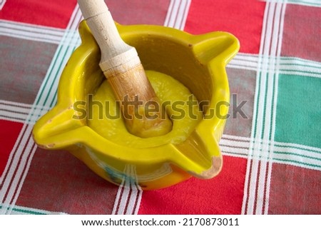 Close up view of a mortar and pestle with freshly made "alioli" sauce on a classic green and red checkered tablecloth Royalty-Free Stock Photo #2170873011