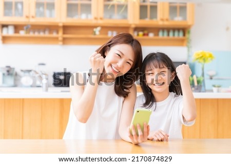 young asian mother and daughter,smart phone