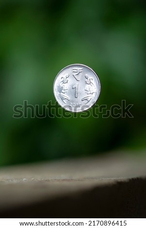 1 rs indian coin with Green blur background Royalty-Free Stock Photo #2170896415