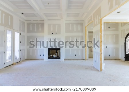 To prepare the walls of a newly constructed house to be painted, finishing putty is applied to the walls of an empty apartment Royalty-Free Stock Photo #2170899089