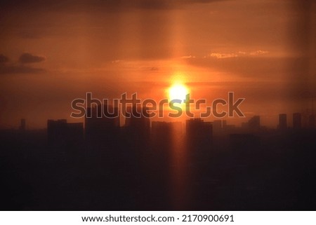 This photo was taken in front of the window vitrage resulting in a defocus picture of beautiful sunset and Jakarta city view.