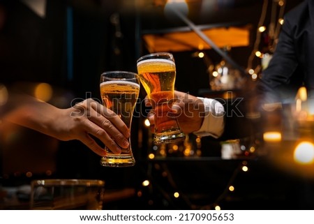 food and drink male friends are happy drinking beer and clinking glasses at a bar or pub. Royalty-Free Stock Photo #2170905653